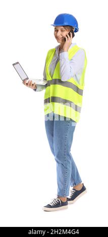 Female construction worker with laptop talking by mobile phone on white background Stock Photo