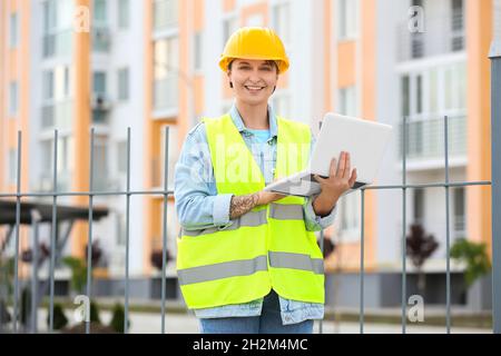 Female construction worker using laptop outdoors Stock Photo