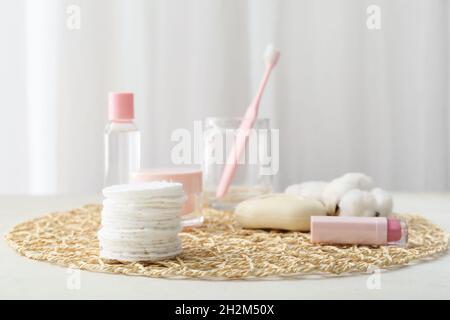 Wicker mat with clean cotton pads and bottle of essential oil on table,  closeup Stock Photo - Alamy