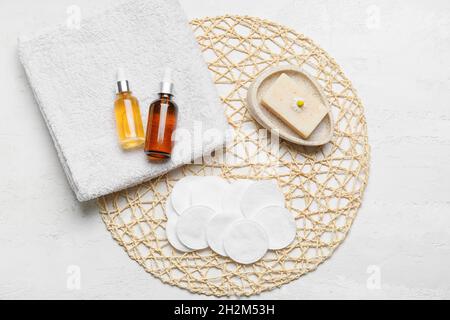 Wicker mat with clean cotton pads and bottle of essential oil on table,  closeup Stock Photo - Alamy