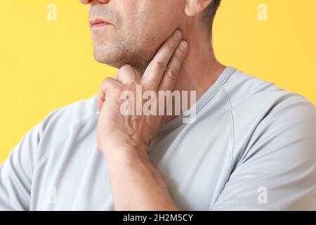 Male runner checking pulse on color background Stock Photo