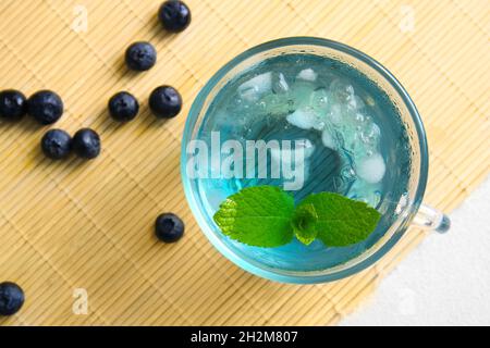 Glass cup of iced blue tea with blueberry on light background, closeup Stock Photo