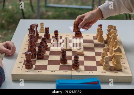 women's hands on the chessboard at the table on the street at competitions. Stock Photo