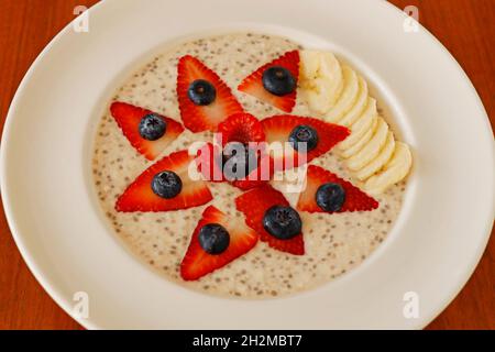 homemade porridge oatmeal cooked in almond milk with berries and banana Stock Photo