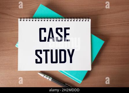 The text Case study is written on a notebook and a wooden table Stock Photo