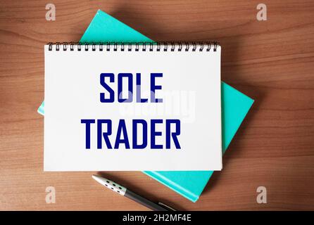 Top view of the written phrase SOLE TRADER, on a wooden background. Business concept. Stock Photo