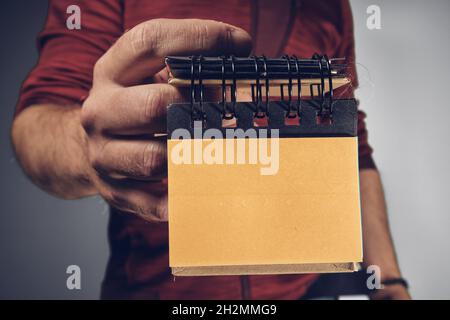 Man holding dirty sticky notes in the hand Stock Photo