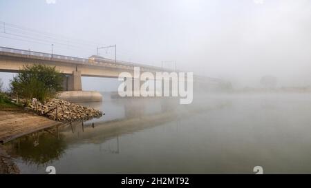 Railway bridge disappearing in the mist. Stock Photo