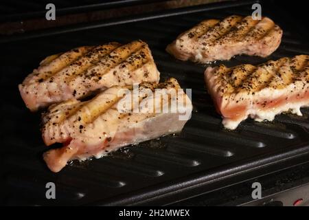 The process of frying salmon fillets at home on an electric grill Stock Photo