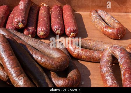 Few appetizing rustic homemade sausages lying at the village fair trade tent Stock Photo