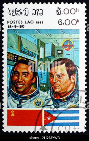 LAOS - CIRCA 1983: a stamp printed in Laos shows Cosmonauts and Flags of USSR and Cuba, Intercosmos Space Cooperation Program, circa 1983 Stock Photo