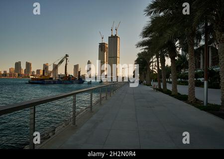 Lusail Corniche at the marina  in Lusail city, Qatar daylight view showing people walking on the promenade  and skyline in background Stock Photo