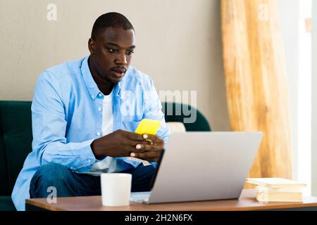 Male freelance worker using smart phone while working at home Stock Photo