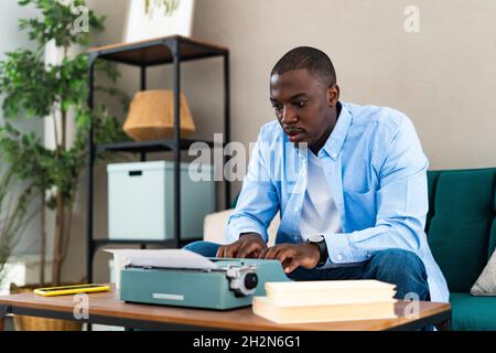 Man holding rugby ball while sitting on sofa at home Stock Photo
