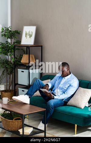 Smiling male freelance worker using digital tablet while working from home Stock Photo