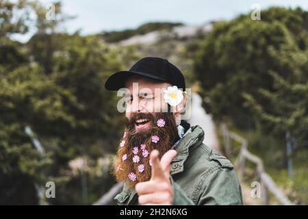 Happy young man wearing flowers gesturing while winking eye Stock Photo