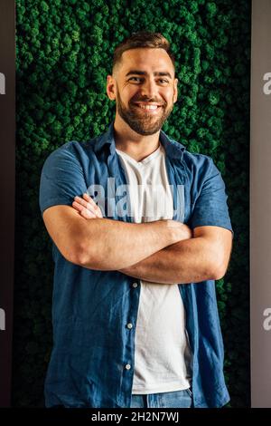 Smiling handsome man standing with arms crossed Stock Photo