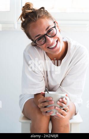 Woman smiling while sitting on stool Stock Photo