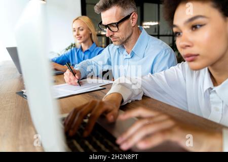 Businessman working with female workers in office Stock Photo