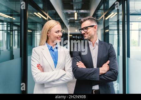 Smiling male and female business professionals looking at each other in office Stock Photo