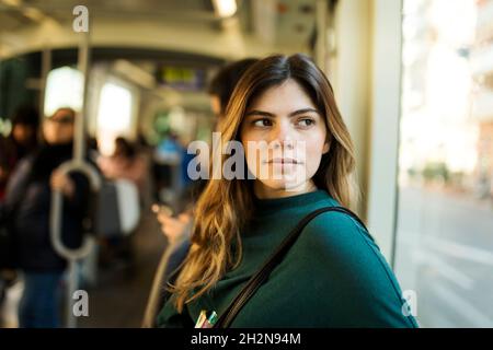 Young woman looking through window while travelling in tram Stock Photo