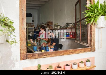 Mid adult couple working together in workshop Stock Photo