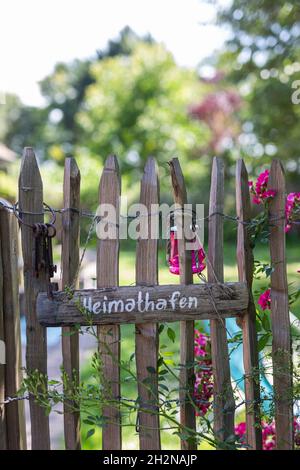 Wooden sign and old key ring hanging on rustic fence Stock Photo