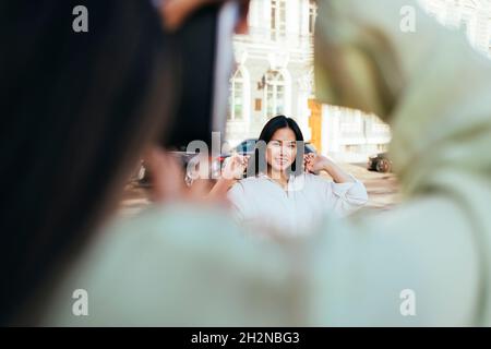 Young woman photographing female friend through camera Stock Photo