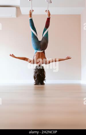 Sportswoman with upside down practicing yoga at studio Stock Photo