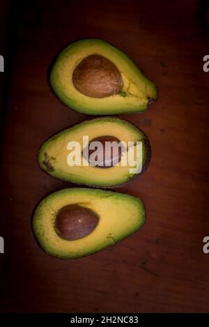 Sliced avocados on wooden table Stock Photo