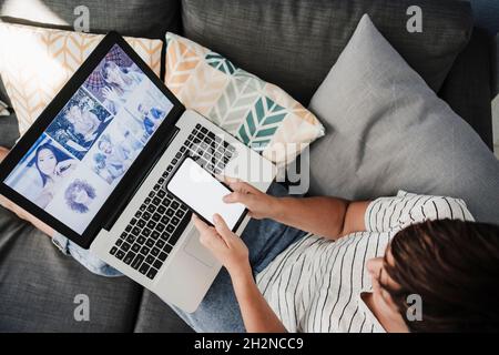 Female freelancer using smart phone during video call with colleagues at home Stock Photo
