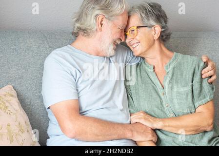Happy couple sitting on sofa at home Stock Photo