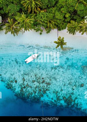 Aerial image of motorboat floating in a turquoise blue sea water. The ...
