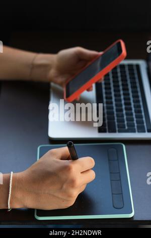 Female student using graphic tablet and mobile phone at cafe Stock Photo