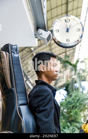 Happy young businessman holding disposable coffee cup talking on mobile phone Stock Photo