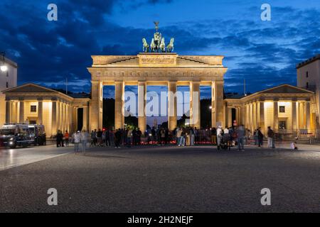 Germany, Berlin, People gathering in front of Brandenburg Gate at night Stock Photo