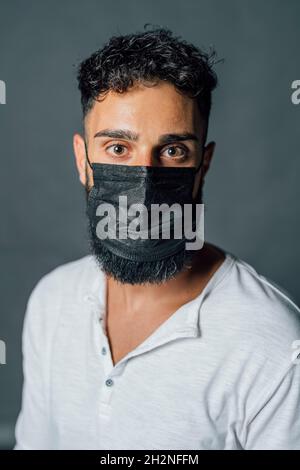 Young man wearing protective face mask in studio Stock Photo