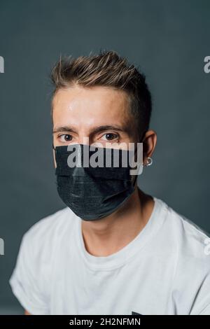 Young man wearing protective face mask in studio Stock Photo