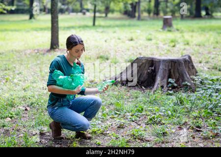 Woman collecting plastic bottles in park Stock Photo