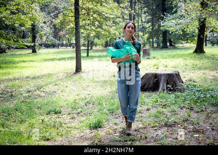 Woman collecting plastic bottles at park Stock Photo