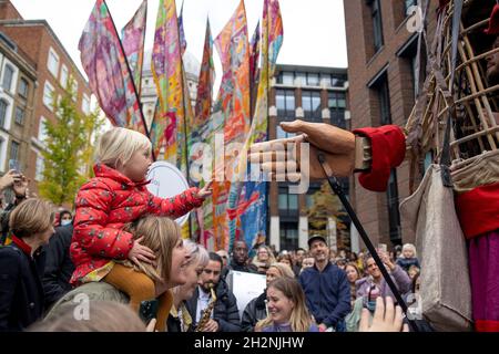 London, UK. 23rd Oct, 2021. Child seen reaching out to connect with Little Amal.Little Amal, a 3.5 meters tall puppet portrayed as a 9 year old Syrian refugee girl and representing all refugee children, arrived central London at the Great Door of the St Paul Cathedral. She has been on journey since July this year departing from the Syrian-Turkish border in search of her 'mother'. She will walk 8000 km and arrive at Manchester in early November as her final destination, where it is also the location of the short term holding facility for refugees in the UK. Credit: SOPA Images Limited/Alamy Liv Stock Photo