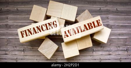 business concept. On a wooden background blocks with the text Funding Available Stock Photo