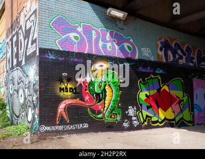 Colourful graffiti / street art next to the River Aire riverside path in Leeds, West Yorkshire Stock Photo