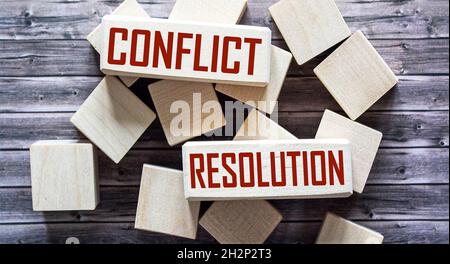 CONFLICT RESOLUTION, the phrase is written on wooden blocks and brown background Stock Photo