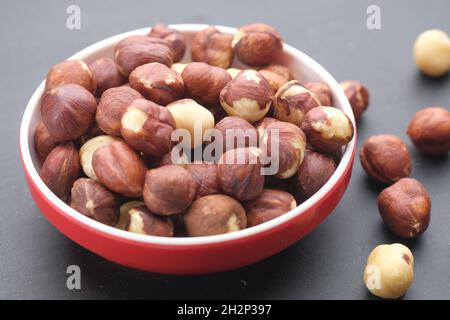 hazelnuts in a container on black background, Stock Photo