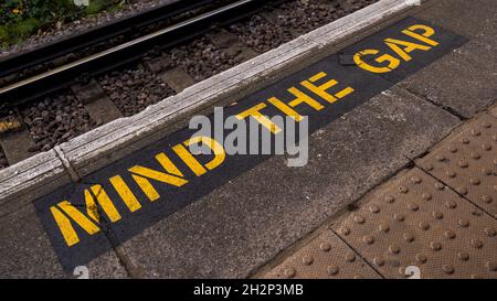 Mind The Gap Sign Painted On A Railway Station Platform Edge In Epsom, Surrey With No People Stock Photo