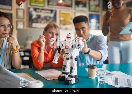 Group of young engineers collaborating together on a robot Stock Photo