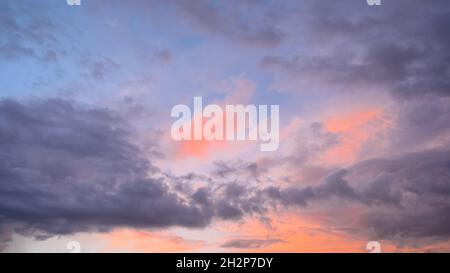 Cumulus sunset clouds, sun setting down. Stock Photo