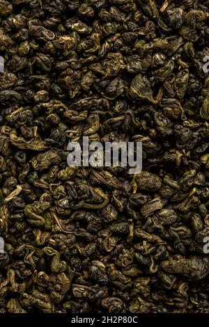 Heap of dry tea leaves. Dried green tea. Textured background of dried leaves of aromatic tea. Stock Photo