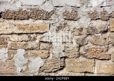 Fragment of an old shell rock wall stained with cement mortar. Several shell bricks are laid out horizontally. Stock Photo
